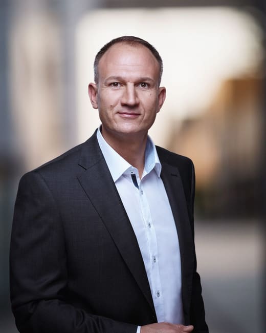 Portrait corporate d'un homme en veste sombre et chemise claire