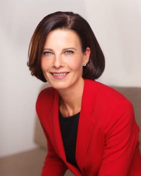 Portrait corporate d'une femme en veste rouge sur fond clair