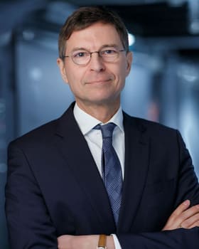 Portrait d'un dirigeant, bras croisés, dans un couloir technique